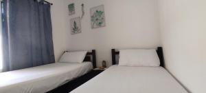 2 camas individuales en una habitación con ventana en Casa MeyMar, en Mompós