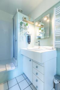a white bathroom with a sink and a shower at Rue Bien Assis avec jardin terrasse in Clermont-Ferrand +15 photos
