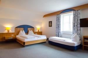 a bedroom with two beds and a window at Goldenes Schiff Hotel-Mietparkplätze in Engelhartszell