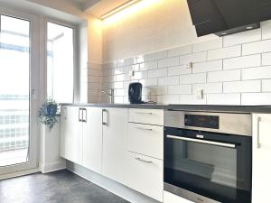 a kitchen with white cabinets and an oven at Newly Renovated Apartment With 1 Bedroom In Kolding in Kolding