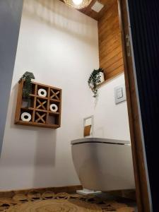 łazienka z toaletą i półką z rolkami papieru toaletowego w obiekcie Le Spa Parmentine, jacuzzi hammam w mieście Rochefort