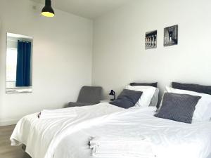 a bedroom with a large white bed and a chair at Newly Renovated Apartment With 1 Bedroom In Kolding in Kolding