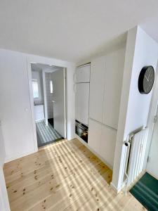 uma cozinha com armários brancos e piso em madeira em Great Modern Studio em Aalborg