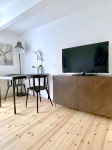 - un salon avec une table et une télévision à grand écran dans l'établissement Great Modern Studio, à Aalborg