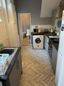 a kitchen with a washer and dryer in it at Howe - Newly refurbished 2 bedroom flat Free Parking in Gateshead