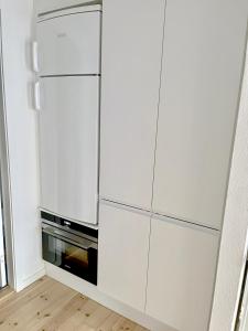 einen weißen Kühlschrank in einer Küche mit Mikrowelle in der Unterkunft Great Modern Studio in Aalborg