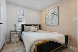 1 dormitorio con 1 cama con manta blanca en Luxe Lodges on Lake Erie en Port Dover