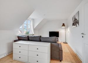 sala de estar con sofá y cómoda blanca en One Bedroom Apartment In Aarhus, Ole Rmers Gade 104 en Aarhus