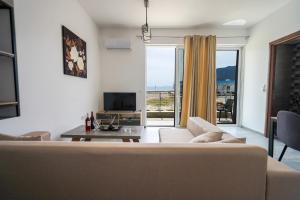 a living room with a couch and a tv at Sunshine House Kos - Easy living by the sea in Kefalos