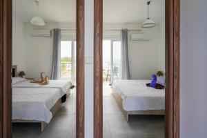 two twin beds in a room with a mirror at Sunshine House Kos - Easy living by the sea in Kefalos