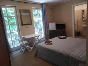 1 dormitorio con cama, mesa y ventanas en AFFITTACAMERE PIAZZA UNITA', en Monfalcone