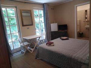 a bedroom with a bed and a table and windows at AFFITTACAMERE PIAZZA UNITA' in Monfalcone