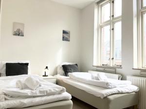 two beds in a room with white walls and windows at Three Bedroom Apartment In Esbjerg, Kronprinsensgade 20 in Esbjerg