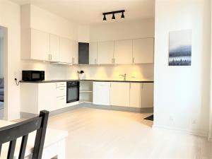 a kitchen with white cabinets and black appliances at Three Bedroom Apartment In Esbjerg, Kronprinsensgade 20 in Esbjerg
