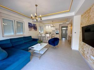 un soggiorno con divano blu e tavolo di Apartments Infinity a Tivat