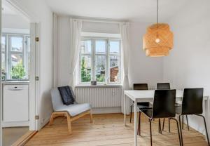 - une salle à manger avec une table, des chaises et des fenêtres dans l'établissement Two Bedroom Apartment In Aarhus, Ole Rmers Gade 104, à Aarhus