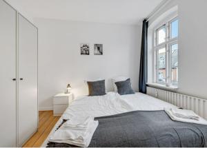- une chambre blanche avec un lit et une fenêtre dans l'établissement Two Bedroom Apartment In Aarhus, Ole Rmers Gade 104, à Aarhus