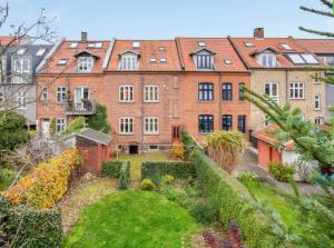 - un grand bâtiment en briques avec un jardin en face dans l'établissement Two Bedroom Apartment In Aarhus, Ole Rmers Gade 104, à Aarhus