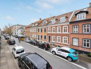 a group of cars parked on a street with buildings at Nice Apartment In A Quite Street In The City Center in Aarhus