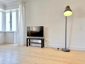 a living room with a flat screen tv and a lamp at Nice Apartment Located Near Vesterbro in Aalborg