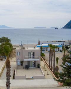 a house with palm trees in front of the ocean at Sunshine House Kos - Easy living by the sea in Kefalos