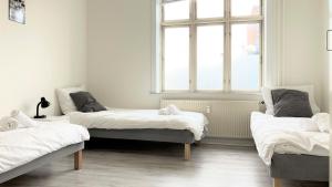 3 camas en una habitación con ventana en Two Bedroom Apartment In Esbjerg, Tordenskjoldsgade 24, en Esbjerg