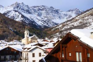 a town with snow covered roofs and a mountain at -Little chalet bardo- [Via Medail 9] in Bardonecchia +9 photos