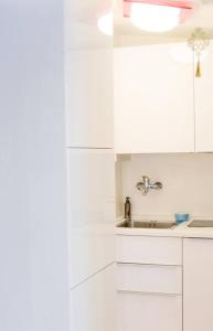 a kitchen with white cabinets and a sink at -Little chalet bardo- [Via Medail 9] in Bardonecchia
