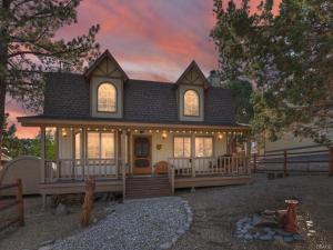 a home with a wrap around porch at sunset at Hikers Haven -Only steps to the National Forest and trails! in Big Bear City