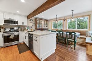 a kitchen with white cabinets and a table with chairs at Casa Luna- Beautiful Maltby style home, just a short drive from Big Bear's attractions! in Big Bear City