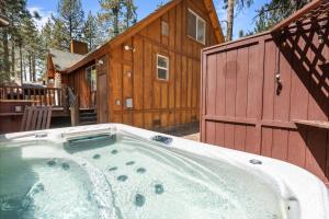 een grote hot tub voor een hut bij Nana Bear Manor - Quiet and spacious log cabin with hot tub perfect for a mountain getaway! in Big Bear City