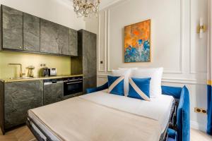 ein Schlafzimmer mit einem Bett mit blauen Kissen in der Unterkunft Luxury 2 Bedroom 1 Bathroom - Louvre Museum & Opera in Paris