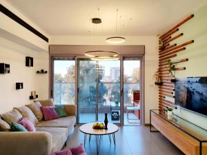 a living room with a couch and a tv and a table at Acrey in Berit Aẖim