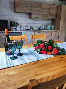 a table with a bunch of roses and a bottle of wine at Bojkolandia in Ustrzyki Dolne