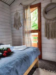 1 dormitorio con 1 cama y una ventana con rosas en Bojkolandia en Ustrzyki Dolne