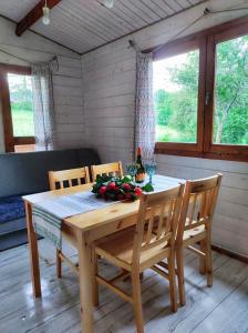 a dining room table with two chairs and a bottle of wine at Bojkolandia in Ustrzyki Dolne