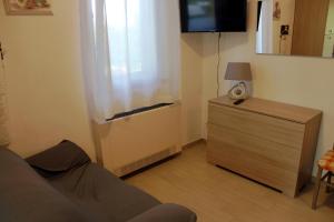 a room with a dresser with a window and a television at Appartamenti l'Olivo in Bagnone