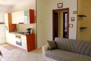 a living room with a couch and a kitchen at Appartamenti l'Olivo in Bagnone