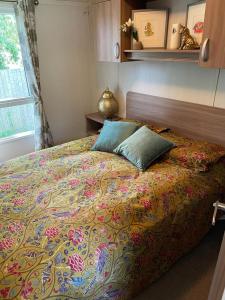 a bedroom with a large bed with a colorful blanket at Forest edge in Saint Leonards