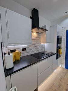 a kitchen with white cabinets and a black counter top at Balco Plaza Studio in Nottingham