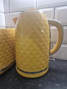 Una taza amarilla sobre un mostrador de una cocina. en Balco Plaza Studio, en Nottingham