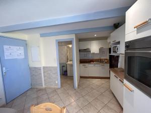 een keuken met witte kasten en een blauw plafond bij F2 apartments with panoramic sea views in Farinole