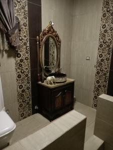 een badkamer met een wastafel met een spiegel en een toilet bij Eastern Nights in Caïro