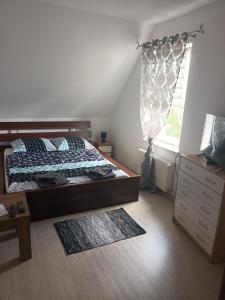 um quarto com uma cama, uma cómoda e uma janela em Pokoje u Izy Stare Kiejkuty em Szczytno