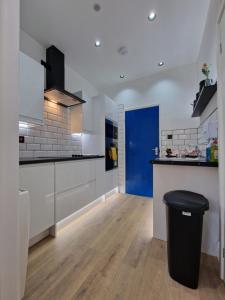 una cocina con armarios blancos y una puerta azul en Balco Plaza Studio, en Nottingham 53 fotos más
