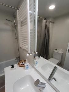 Baño blanco con lavabo y espejo en La Casita de Requejo en Zamora