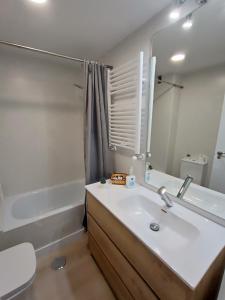a bathroom with a sink and a tub and a mirror at La Casita de Requejo in Zamora