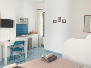 a living room with a blue chair and a kitchen at Rosa Dei Venti Marettimo in Marettimo
