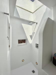 Sunset Pyrgos في بيرغوس: غرفة بجدران بيضاء وسقف مع نافذة