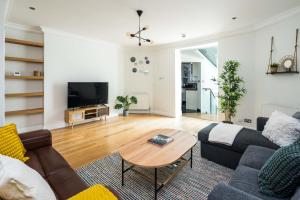 sala de estar con sofá y mesa en Elegant 2BD Duplex with Outdoor Patio/Glass Canopy, en Londres